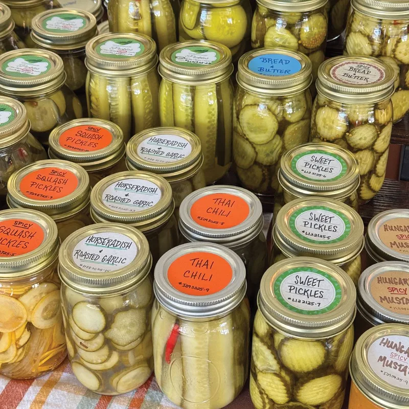 Jars of house-made pickles stacked at a Dallas Farmers Market stall