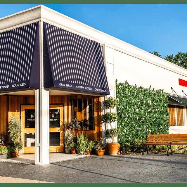 The Hudson House Lakewood storefront with its navy awning and patio bench