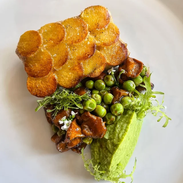 A refined French-Vietnamese plate with golden plantain crisps, spring peas, and greens at Mot Hai Ba