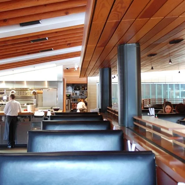The warm wood-lined dining room and open kitchen at R+D Kitchen