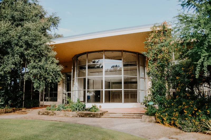 The curved glass entrance of Texas Discovery Gardens at Fair Park