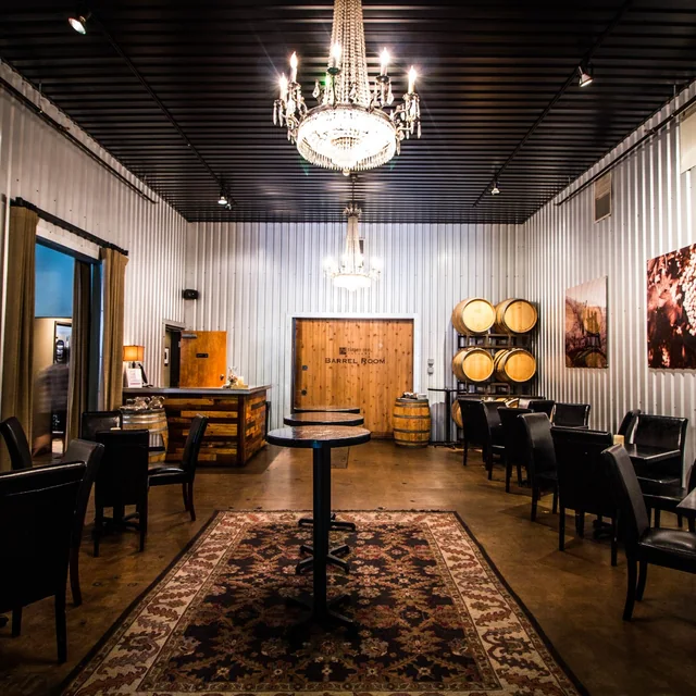 The Times Ten Cellars tasting room with a chandelier, wine barrels, and cafe tables in a 1945 post-office building