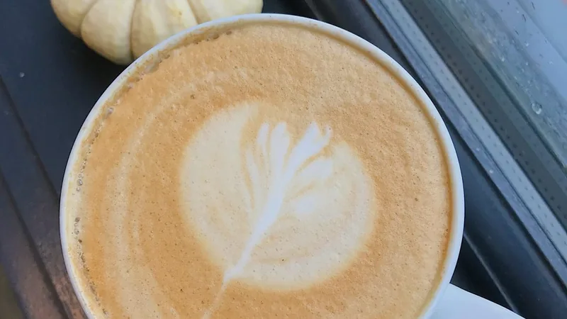 A cold Village Blend coffee alongside a warm, buttery croissant at Village Baking Co.