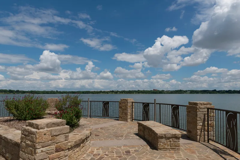 The stone Maurice Levy Overlook on the White Rock Lake Trail under a big Texas sky