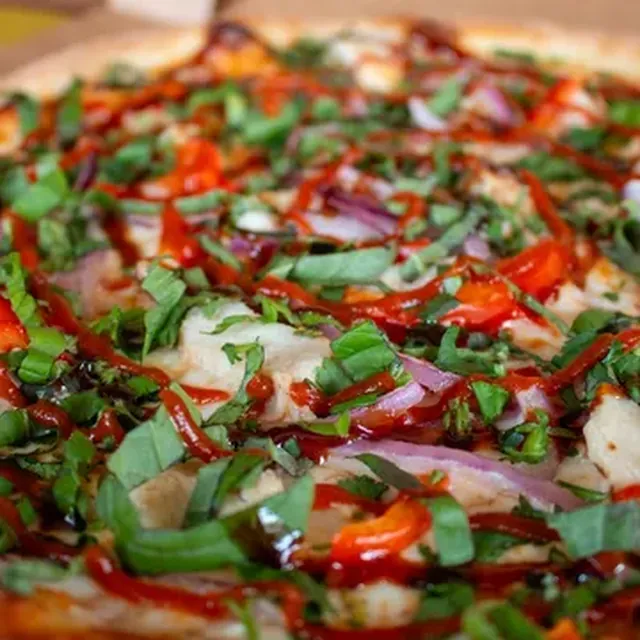 A Pho Shizzle pizza with basil, red onion, and sriracha from Zalat Pizza