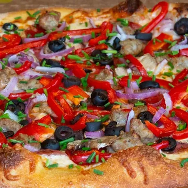 A Zealot supreme pizza with peppers, olives, and sausage from Zalat Pizza