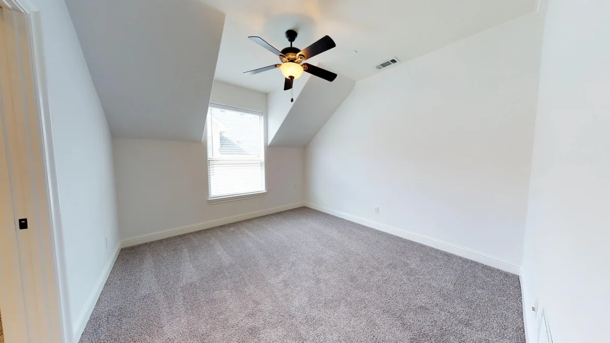 Carpeted bedroom with a peaked ceiling, ceiling fan, and blinded window