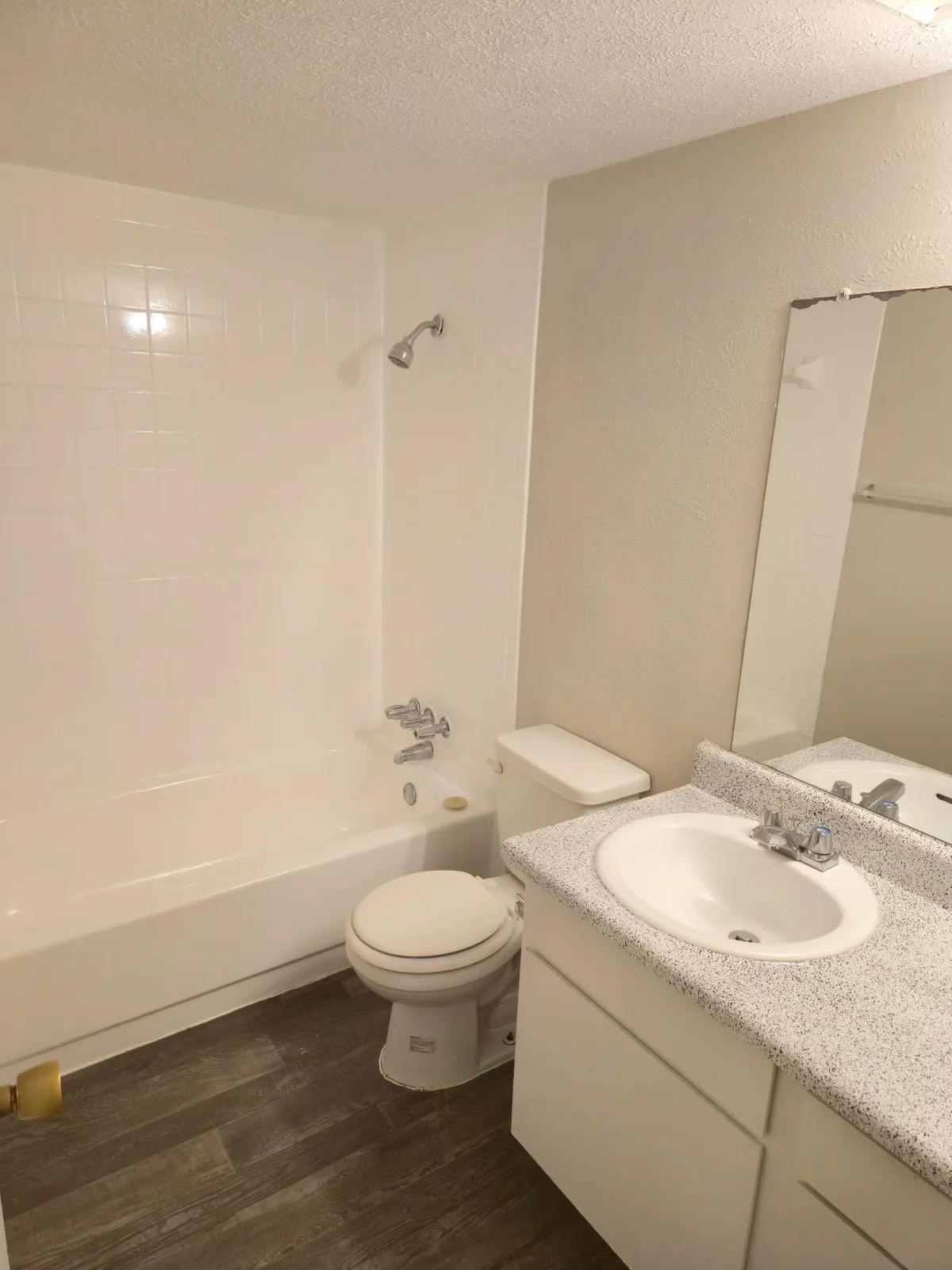 Bathroom with a tiled tub-and-shower, single vanity, and a framed mirror