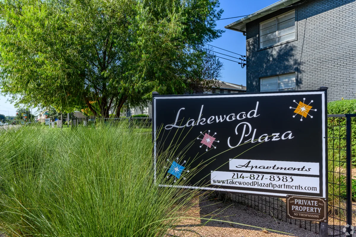 Lakewood Plaza monument sign amid ornamental grasses with the brick building rising behind
