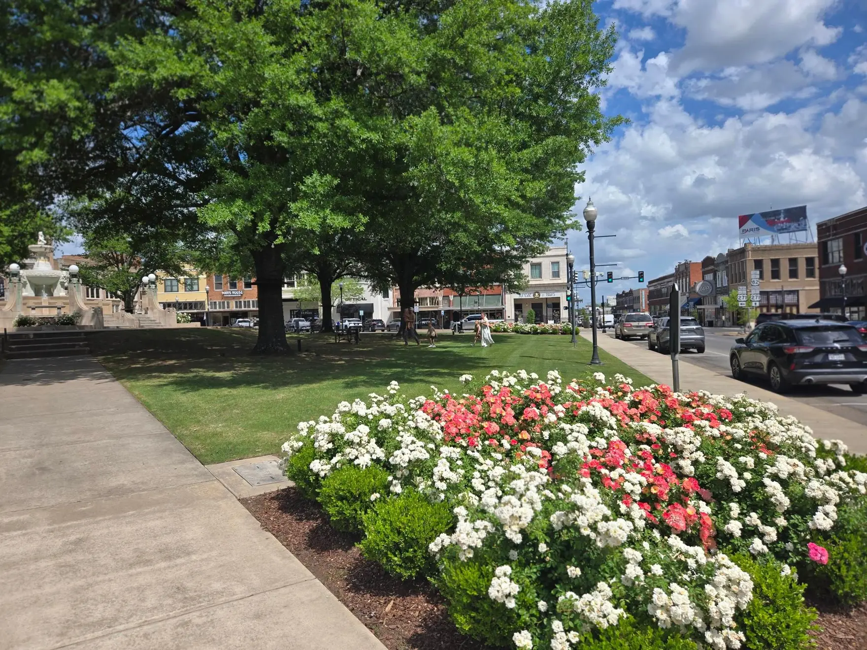 Rose beds in bloom beside the stone fountain on the downtown Paris, Texas courthouse square