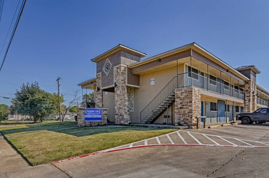 Angled street view of the two-story building with property signage and open parking