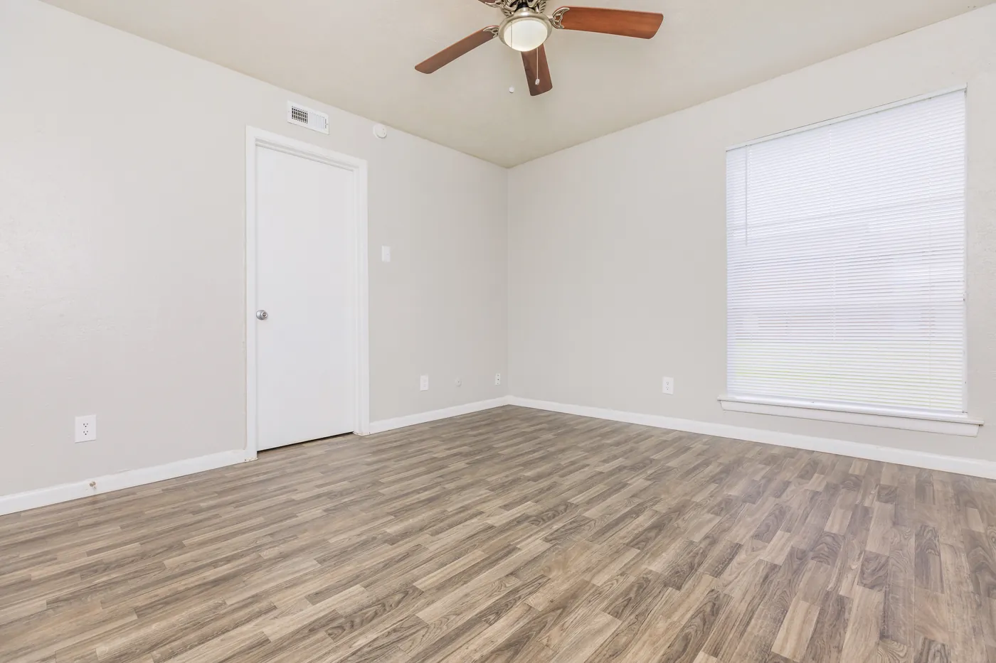 Bedroom with ceiling fan, window, and wood-look flooring