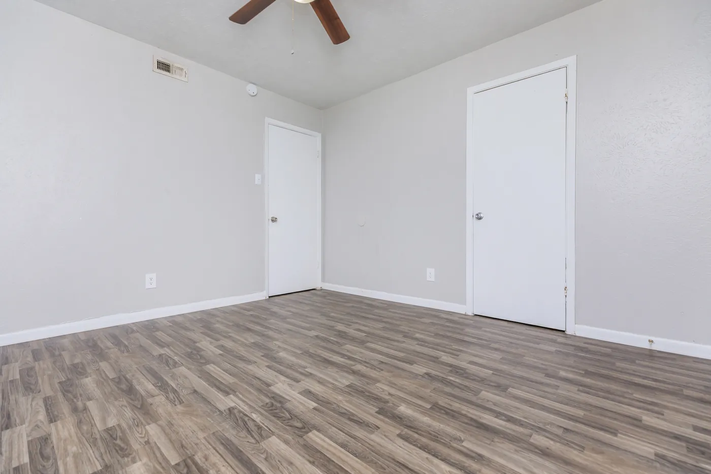 Bedroom with ceiling fan and closet doors