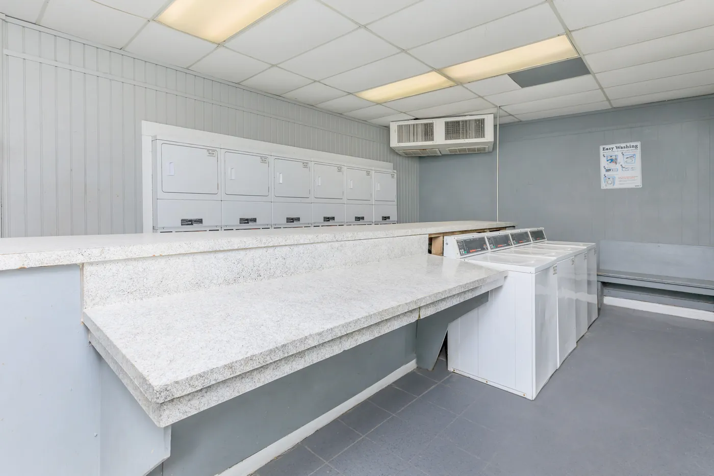 Community laundry room with a long folding counter and machines