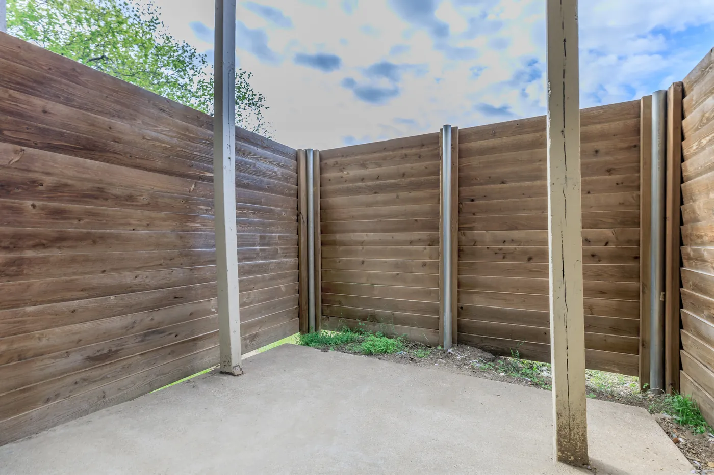 Private patio enclosed by a tall wooden privacy fence