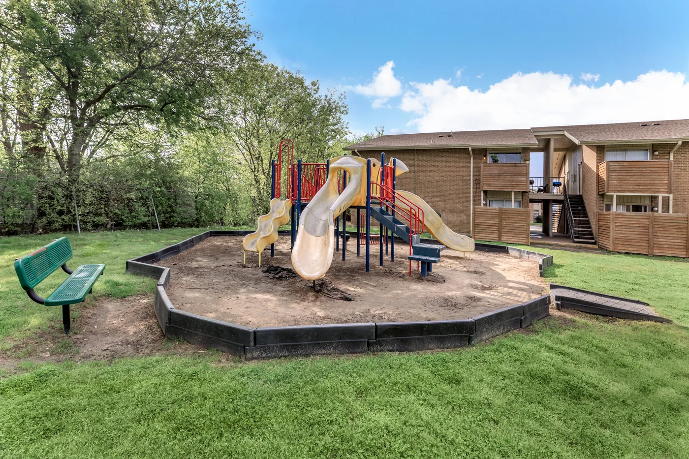 Playground with dual slides on the lawn between residences
